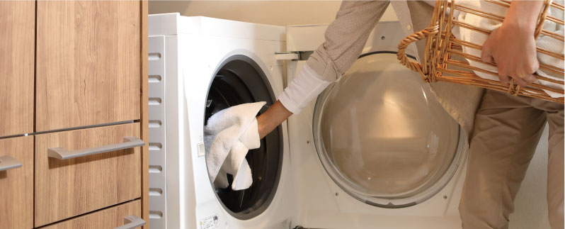 写真：ドラム洗に洗濯物を入れるところ