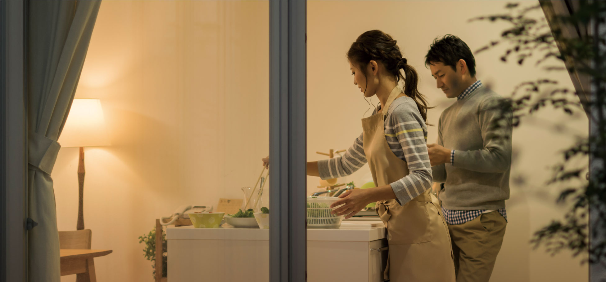 ハイブリッド蓄電システムとの連携のキービジュアルです。キッチンで調理している夫婦の画像です。